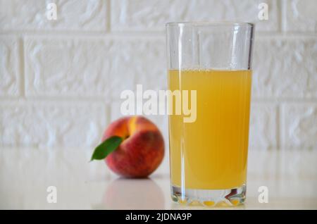 Jus de pêche frais sur fond blanc. Banque D'Images