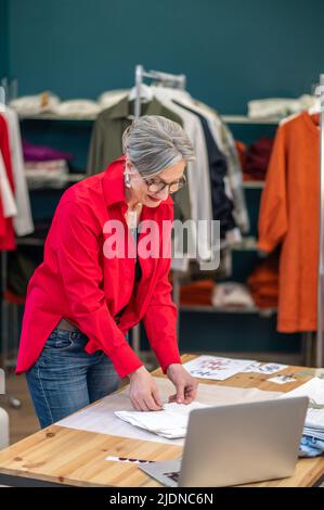 Femme debout près de la table pliante vêtements Banque D'Images