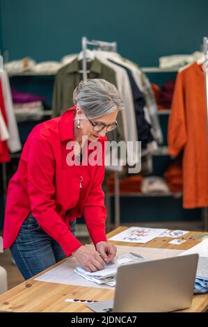 Femme emballant soigneusement les vêtements pliés sur la table Banque D'Images