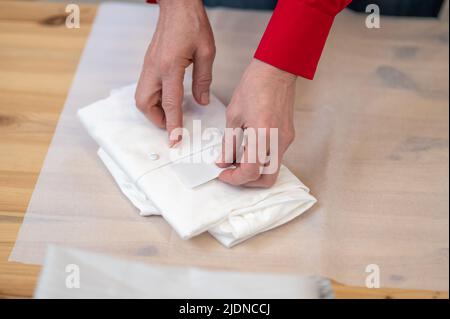 Vue du dessus des mains mettant la carte dans une chemise pliée Banque D'Images