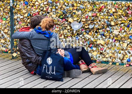 PARIS, FRANCE - 14 MAI 2013 : un jeune couple inconnu regarde beaucoup de "l'écluse de l'Amour" sur le célèbre pont des amoureux de Paris - le pont de l'Art Banque D'Images