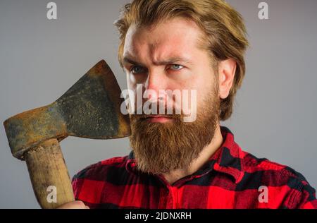 Homme barbu sérieux avec hachet. Bûcheron canadien avec vieille hache. Coupe du bois. Outils de l'enregistreur. Banque D'Images