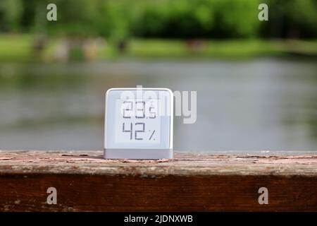 Thermomètre avec fonction de mesure de l'humidité sur la rive du lac. Exposition avec technologie e-Ink, temps chaud d'été pour les loisirs dans le parc Banque D'Images