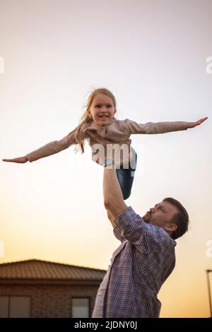 papa jouant avec sa fille dans l'arrière-cour de la maison. Banque D'Images