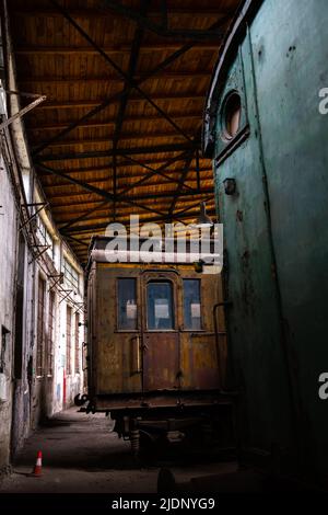 Les anciennes voitures de passagers se trouvent dans le bâtiment du hangar historique des locomotives. La photo a été prise dans des conditions d'éclairage naturel Banque D'Images