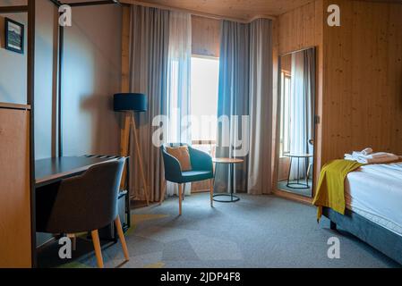 Intérieur d'une chambre confortable de style rustique dans un complexe luxueux pendant la journée ensoleillée Banque D'Images