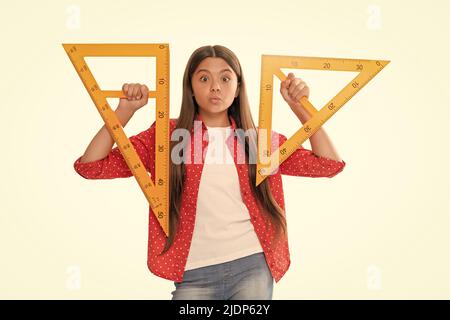 drôle positif fille de l'adolescence tenir triangle d'étude de règle mathématique à l'école isolée sur blanc, l'éducation Banque D'Images