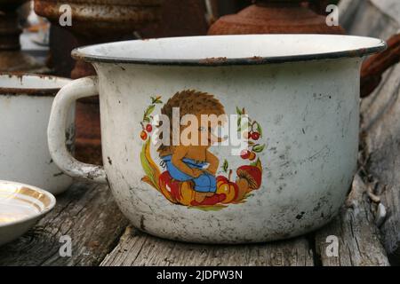 Izborsk, Musée en plein air, Oblast de Pskov, Russie. 7 de septembre 2018. Vieux pot blanc en étain avec le motif hérisson. Pot de chambre vintage Banque D'Images