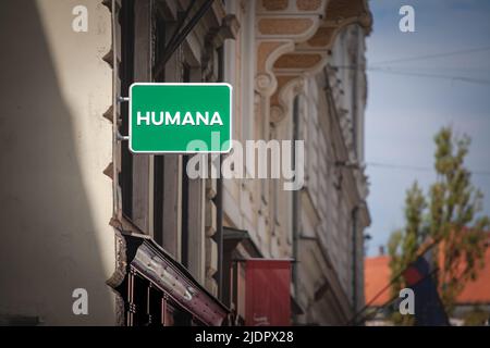 Photo d'un signe avec le logo des personnes Humana à des gens sur leur magasin d'occasion à Ljubljana, Slovénie. Humana est un organisme de bienfaisance spécial Banque D'Images