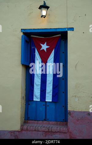 drapeau cubain couvrant la porte dans les rues de trinidad Banque D'Images