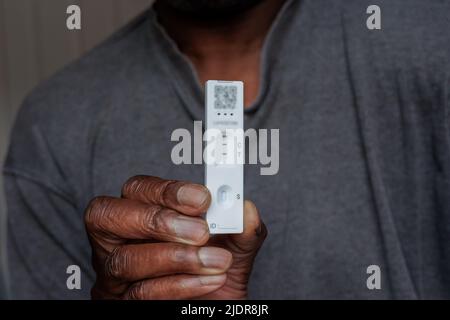 Personne d'origine africaine détenant un seul test positif d'antigène de flux latéral à domicile rapide Covid-19 Banque D'Images