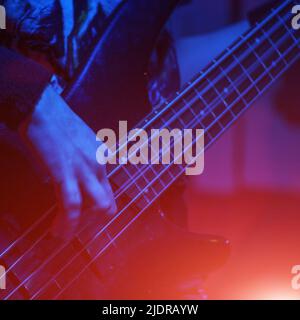 Le guitariste de basse joue la guitare de basse sous les projecteurs. Mise au point sélective Banque D'Images