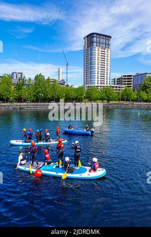 Les enfants font du canoë sur les vieux quais de Salford, Manchester, Royaume-Uni, maintenant connu sous le nom de Salford Quays Banque D'Images