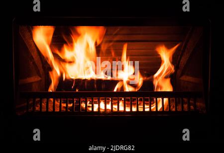 Le feu brûle dans une cheminée la nuit, photo de fond abstraite Banque D'Images