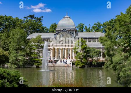 Crystal Palace. Bâtiment situé dans le parc Retiro de Madrid avec ses fenêtres en verre entourées d'arbres et de végétation verte par une journée ensoleillée Banque D'Images