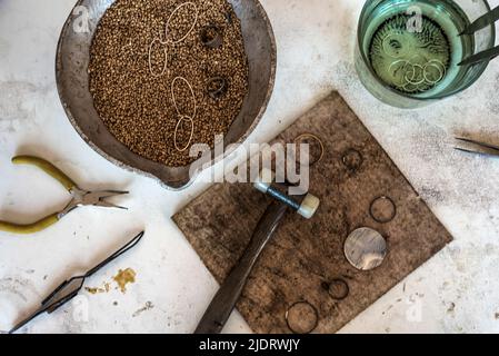 Vue de dessus bijoux établi avec outils sur table. L'équipement et des outils d'un orfèvre sur un bureau de travail en bois à l'intérieur d'un atelier. Banque D'Images