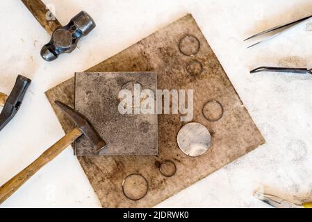 Vue de dessus bijoux établi avec outils sur table. L'équipement et des outils d'un orfèvre sur un bureau de travail en bois à l'intérieur d'un atelier. Banque D'Images