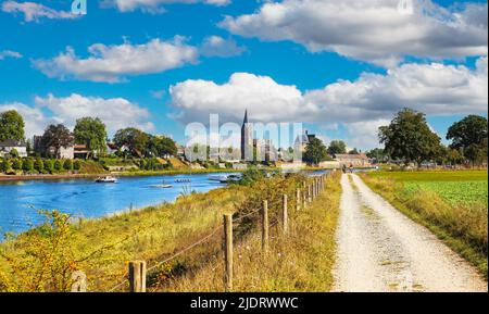 Beau paysage rural hollandais, chemin cyclable à la gare de ferry, ville médiévale église tour, rivière Maas - vue de Beesel sur Kessel, pays-Bas Banque D'Images