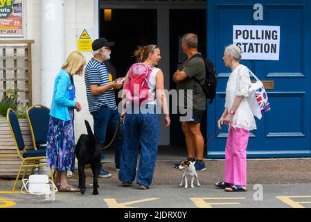 Axminster, Devon, Royaume-Uni. 23rd juin 2022. Les électeurs avec des chiens entrent dans un bureau de vote à la salle Guild Hall d'Axminster à Devon pour voter pour l'élection parlementaire de la circonscription de Tiverton et de Honiton. Crédit photo : Graham Hunt/Alamy Live News Banque D'Images