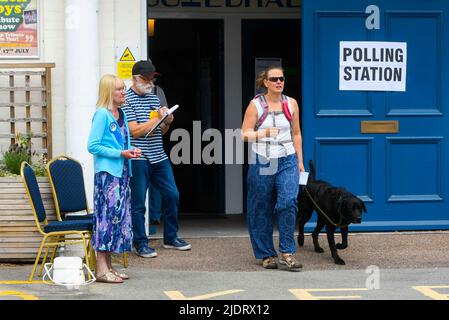 Axminster, Devon, Royaume-Uni. 23rd juin 2022. Un électeur avec un chien quitte le bureau de vote à la salle Guild Hall d'Axminster à Devon après avoir voté pour l'élection parlementaire de la circonscription de Tiverton et de Honiton. Crédit photo : Graham Hunt/Alamy Live News Banque D'Images