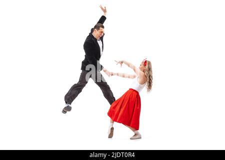 Jeune homme et femme étonnés en tenues rétro dansant le houblon de lindy isolé sur fond blanc. Art, musique, mode, concept de style Banque D'Images