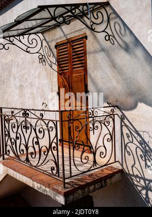 Le soleil projette de nombreuses ombres d'un auvent en fer forgé et d'une clôture dans une porte d'une maison provençale dans le village de Villars sur Var dans les Alpes basses Banque D'Images