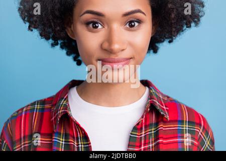 Photo de jeune magnifique magnifique bonne humeur afro femme souriante tranquillement isolée sur fond bleu Banque D'Images