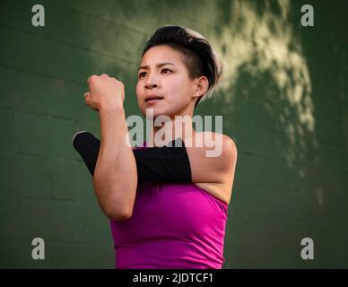 Femme athlétique avec main amputée étirant le bras Banque D'Images