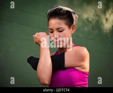 Femme athlétique avec main amputée étirant le bras Banque D'Images