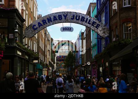 Carnaby Street Londres Angleterre Royaume-Uni avec un arc-en-ciel pour la gay Pride et un signe Carnaby Jubilee pour le Platinum Jubilee juin 2022 Banque D'Images