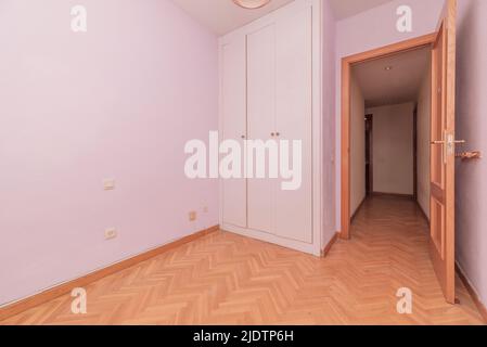 Cette chambre vide comprend une armoire en bois blanc et du parquet en chêne français à chevrons Banque D'Images