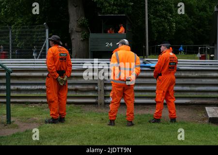 Trois marshalls de sports motorisés, en uniformes orange, sur piste Banque D'Images