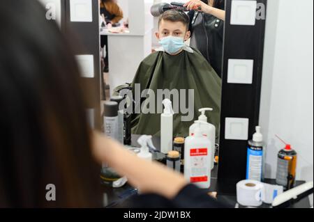 Dolyna, Ukraine 3 février 2022: Visite au coiffeur, coupe de cheveux pour enfants, coiffeurs en Ukraine pendant la quarantaine, coiffeur élégant. Banque D'Images