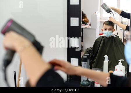 Dolyna, Ukraine 3 février 2022: Visite au coiffeur, coupe de cheveux pour enfants, coiffeurs en Ukraine pendant la quarantaine, coiffeur élégant. Banque D'Images