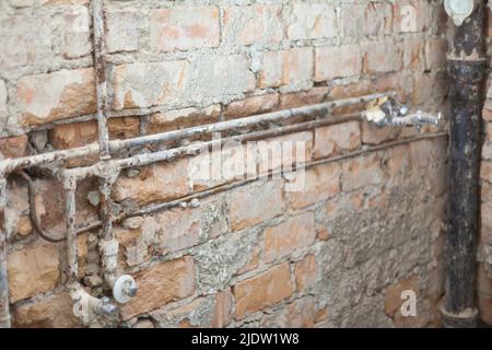 Vieux tuyaux d'eau rouillée et tuyaux d'égout exposés dans un vieux bâtiment Banque D'Images