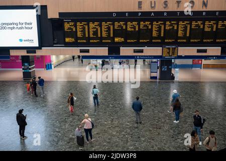 Les passagers espérant faire un voyage en train à travers Euston attendent un service sur le principal hall de la gare le deuxième jour de la grève ferroviaire du Royaume-Uni, lorsque les travailleurs du chemin de fer et du métro de Londres avec le syndicat RMT ont pris des mesures industrielles, la grève ferroviaire la plus perturbatrice en Angleterre, L'Écosse et le pays de Galles pendant trente ans, le 23rd juin 2022, à Londres, en Angleterre. Banque D'Images