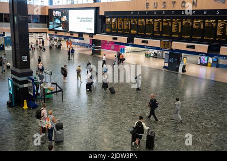 Les passagers espérant faire un voyage en train à travers Euston attendent un service sur le principal hall de la gare le deuxième jour de la grève ferroviaire du Royaume-Uni, lorsque les travailleurs du chemin de fer et du métro de Londres avec le syndicat RMT ont pris des mesures industrielles, la grève ferroviaire la plus perturbatrice en Angleterre, L'Écosse et le pays de Galles pendant trente ans, le 23rd juin 2022, à Londres, en Angleterre. Banque D'Images