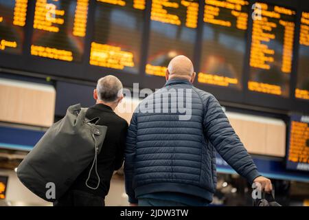 Les passagers espérant faire un voyage en train à travers Euston attendent un service sur le principal hall de la gare le deuxième jour de la grève ferroviaire du Royaume-Uni, lorsque les travailleurs du chemin de fer et du métro de Londres avec le syndicat RMT ont pris des mesures industrielles, la grève ferroviaire la plus perturbatrice en Angleterre, L'Écosse et le pays de Galles pendant trente ans, le 23rd juin 2022, à Londres, en Angleterre. Banque D'Images