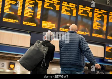 Les passagers espérant faire un voyage en train à travers Euston attendent un service sur le principal hall de la gare le deuxième jour de la grève ferroviaire du Royaume-Uni, lorsque les travailleurs du chemin de fer et du métro de Londres avec le syndicat RMT ont pris des mesures industrielles, la grève ferroviaire la plus perturbatrice en Angleterre, L'Écosse et le pays de Galles pendant trente ans, le 23rd juin 2022, à Londres, en Angleterre. Banque D'Images