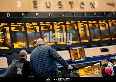 Les passagers espérant faire un voyage en train à travers Euston attendent un service sur le principal hall de la gare le deuxième jour de la grève ferroviaire du Royaume-Uni, lorsque les travailleurs du chemin de fer et du métro de Londres avec le syndicat RMT ont pris des mesures industrielles, la grève ferroviaire la plus perturbatrice en Angleterre, L'Écosse et le pays de Galles pendant trente ans, le 23rd juin 2022, à Londres, en Angleterre. Banque D'Images