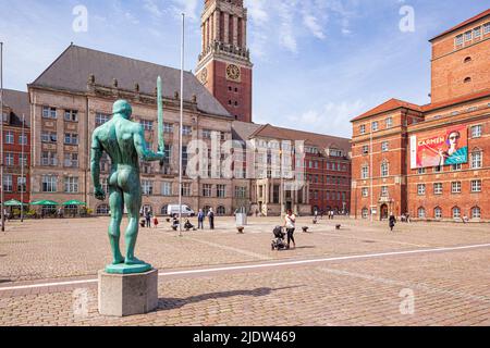 La statue de l'épée du porteur (Schwertträger) sur la place de Kieler Rathausplatz avec l'Hôtel de ville (Landeshauptstadt) et l'Opéra de Kiel Banque D'Images