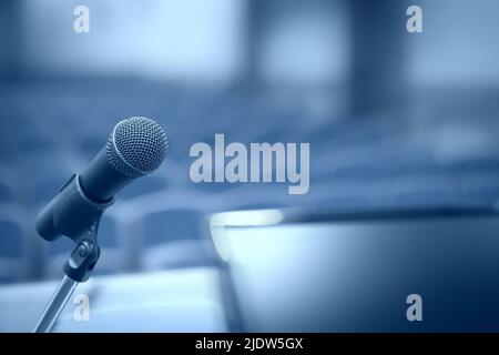 Tribune avec microphone et ordinateur dans la salle de conférence avec effet de flou de mouvement Banque D'Images