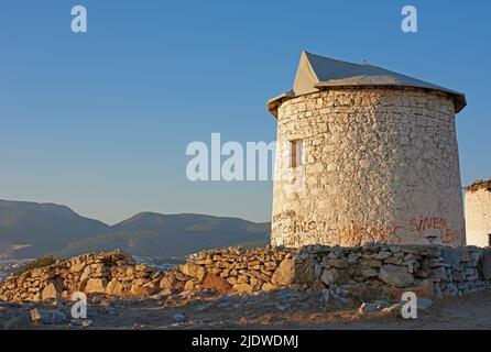 Vieux moulin à vent en ruine près du petit village ou de la campagne. Un bâtiment blanc rond en pierre abandonnée avec des collines verdoyantes en arrière-plan. Le Banque D'Images