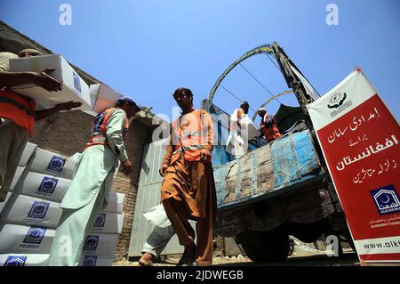 Peshawar, Afghanistan, 23 juin 2022. Des volontaires de la Fondation Al-Khidmat chargent des secours sur des camions alors que la Fondation Al-Khidmat (Jamat-e-Islami) a annoncé d'envoyer des tonnes de provisions et d'articles de secours pour le soutien des populations afghanes touchées par le tremblement de terre, à Peshawar jeudi, au 23 juin 2022. Banque D'Images