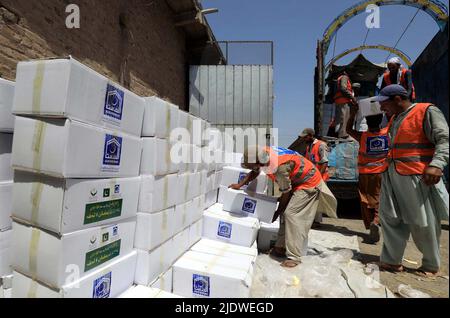 Peshawar, Afghanistan, 23 juin 2022. Des volontaires de la Fondation Al-Khidmat chargent des secours sur des camions alors que la Fondation Al-Khidmat (Jamat-e-Islami) a annoncé d'envoyer des tonnes de provisions et d'articles de secours pour le soutien des populations afghanes touchées par le tremblement de terre, à Peshawar jeudi, au 23 juin 2022. Banque D'Images