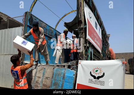 Peshawar, Afghanistan, 23 juin 2022. Des volontaires de la Fondation Al-Khidmat chargent des secours sur des camions alors que la Fondation Al-Khidmat (Jamat-e-Islami) a annoncé d'envoyer des tonnes de provisions et d'articles de secours pour le soutien des populations afghanes touchées par le tremblement de terre, à Peshawar jeudi, au 23 juin 2022. Banque D'Images