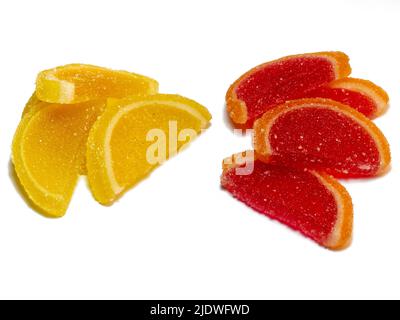 Gelée de fruits sous forme de tranches d'orange et de pamplemousse sur fond blanc. Bonbons sur la table. Isoler avec de la marmelade. Fruits - bonbons Banque D'Images