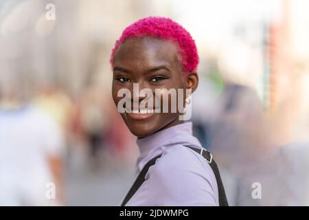 Femme afro moderne et élégante souriant à l'appareil photo Banque D'Images