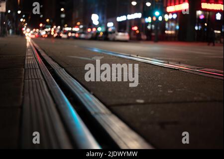 Au niveau de la rue, accent sélectif sur les lignes de tramway la nuit à San Diego. Banque D'Images