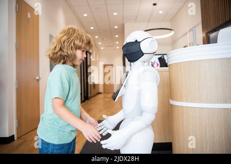 un enfant occupé interagit avec l'intelligence artificielle du robot, la communication Banque D'Images